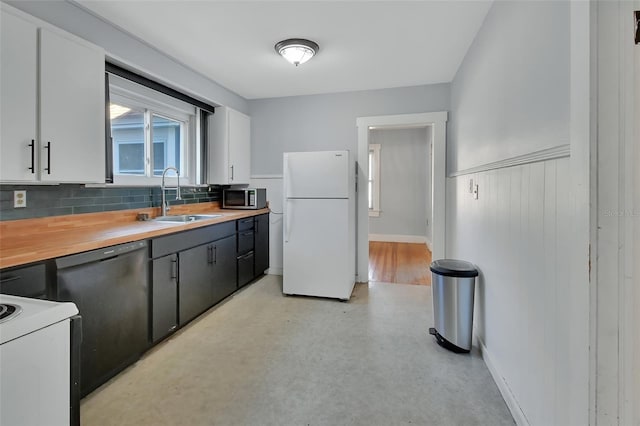 kitchen with white appliances, decorative backsplash, sink, and white cabinets