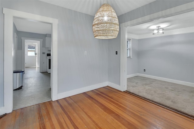 unfurnished dining area with an inviting chandelier and hardwood / wood-style flooring