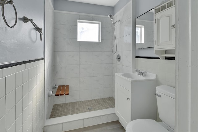 bathroom featuring vanity, toilet, and tile walls