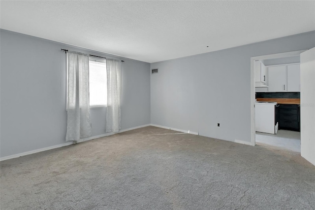 carpeted empty room featuring a textured ceiling