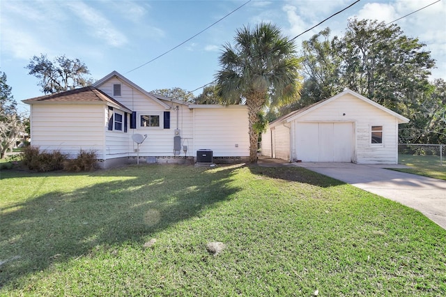 view of front of home featuring cooling unit, a front yard, an outbuilding, and a garage