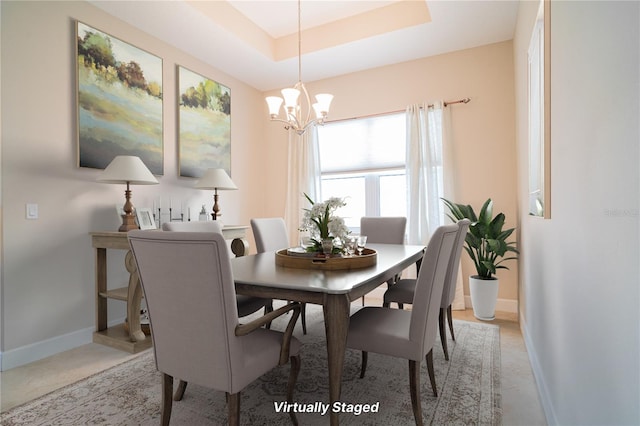 dining area featuring a chandelier and a tray ceiling