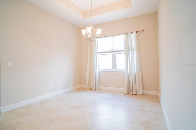 unfurnished room with a tray ceiling and a chandelier