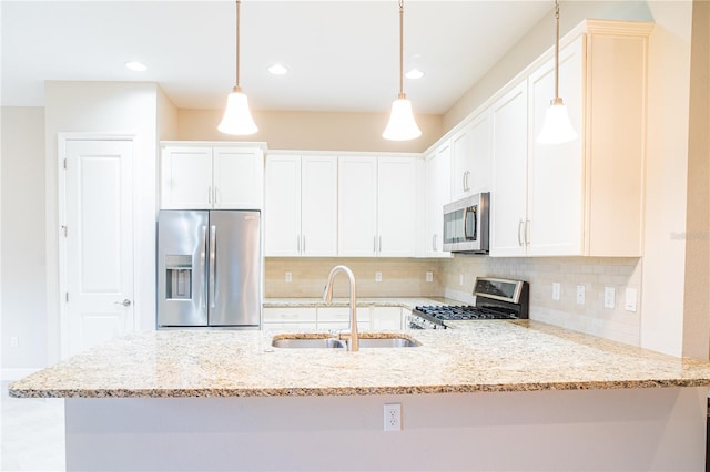 kitchen featuring white cabinetry, light stone countertops, appliances with stainless steel finishes, and sink