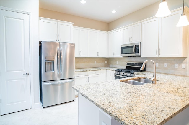 kitchen featuring stainless steel appliances, decorative light fixtures, and white cabinets