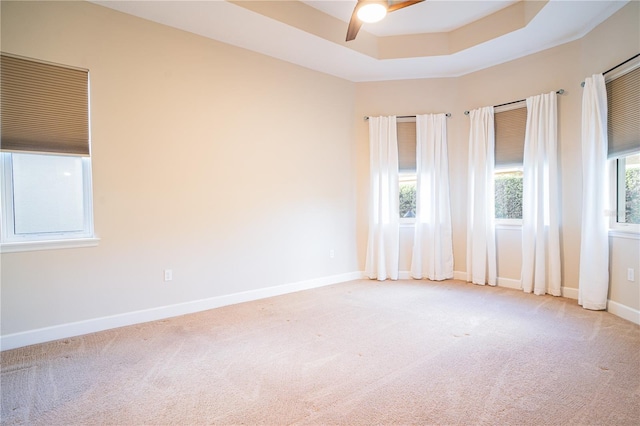 unfurnished room featuring ceiling fan, carpet, and a tray ceiling