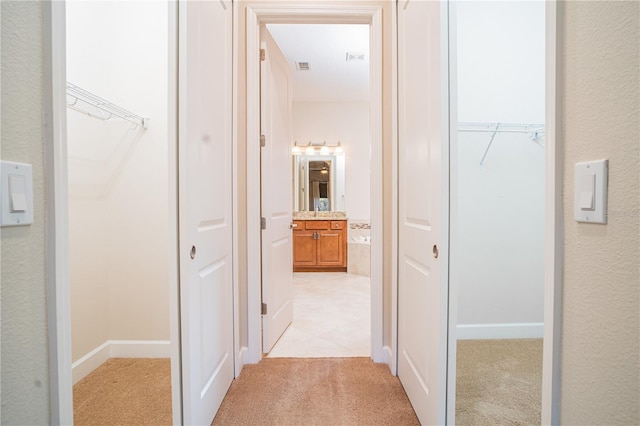 hallway with light colored carpet