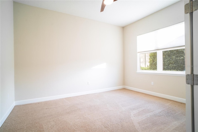 carpeted empty room with a barn door and ceiling fan