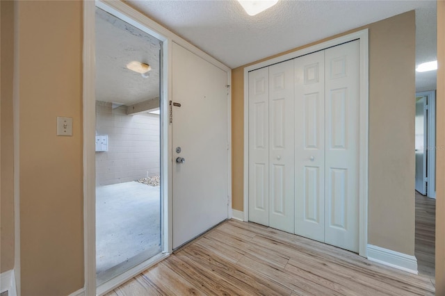 interior space with a textured ceiling and light wood-type flooring