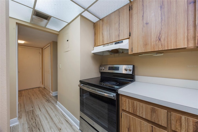 kitchen featuring stainless steel electric range, a paneled ceiling, and light wood-type flooring