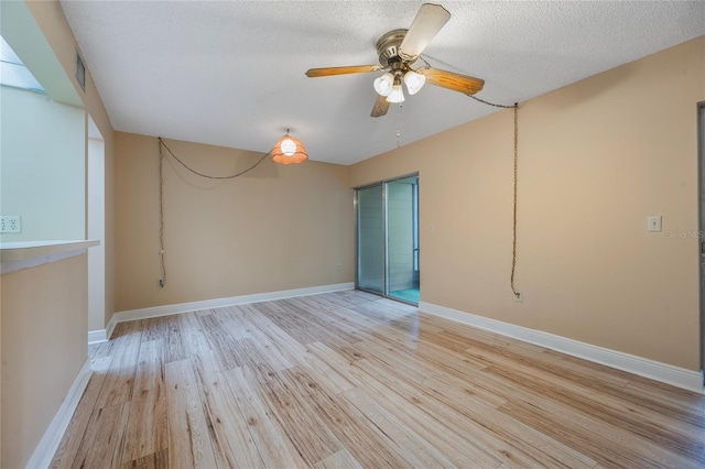 spare room with a textured ceiling, light wood-type flooring, and ceiling fan