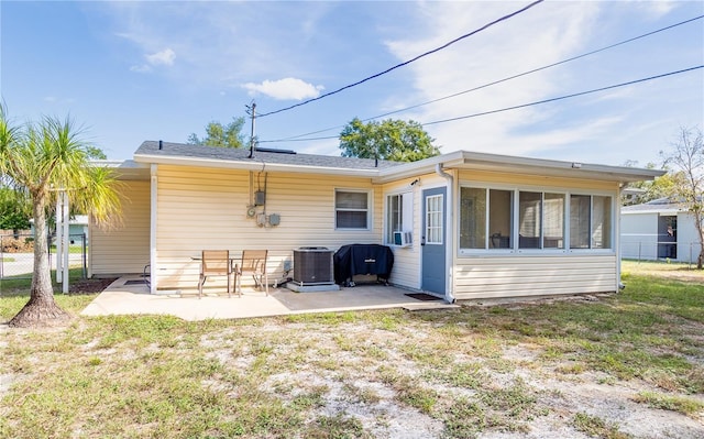 rear view of house with central AC, cooling unit, a patio, and a lawn