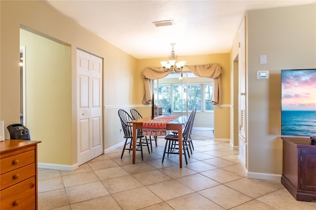 tiled dining space featuring a chandelier