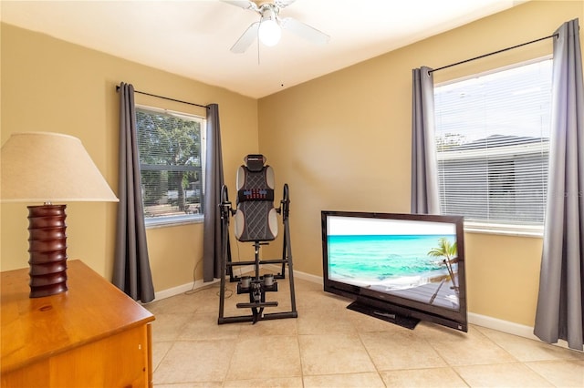 workout area featuring light tile patterned flooring and ceiling fan