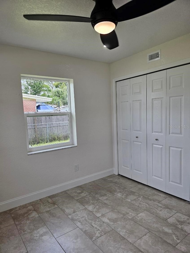 unfurnished bedroom with a closet and ceiling fan