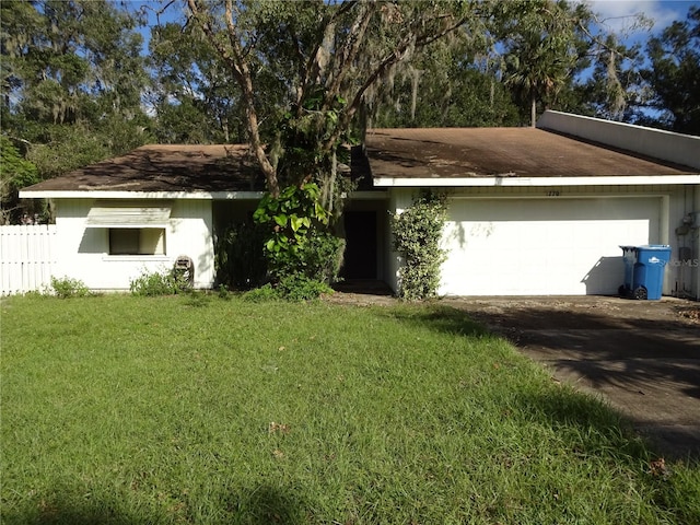 ranch-style house featuring a front lawn and a garage