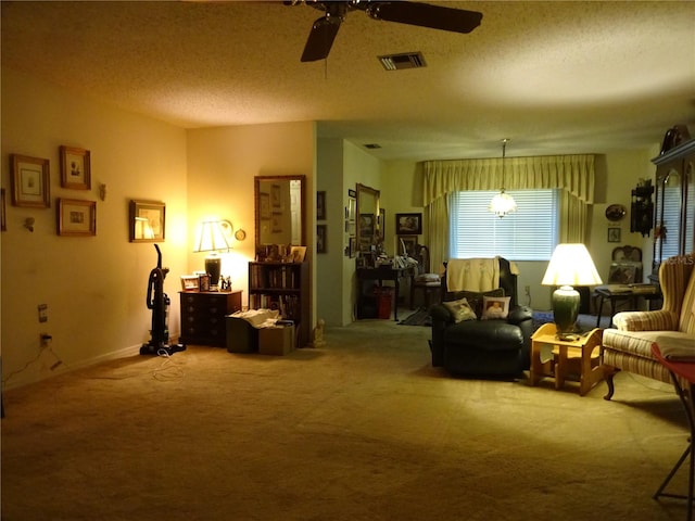 living area with a textured ceiling, carpet, and ceiling fan