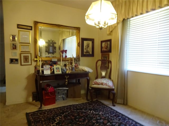 sitting room featuring carpet and an inviting chandelier