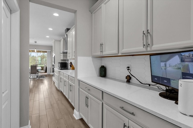 kitchen with white cabinetry, tasteful backsplash, and light wood-type flooring