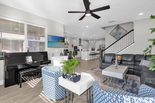 living room with light hardwood / wood-style flooring and ceiling fan