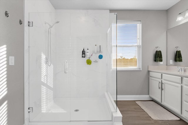 bathroom with vanity, a shower with shower door, and wood-type flooring