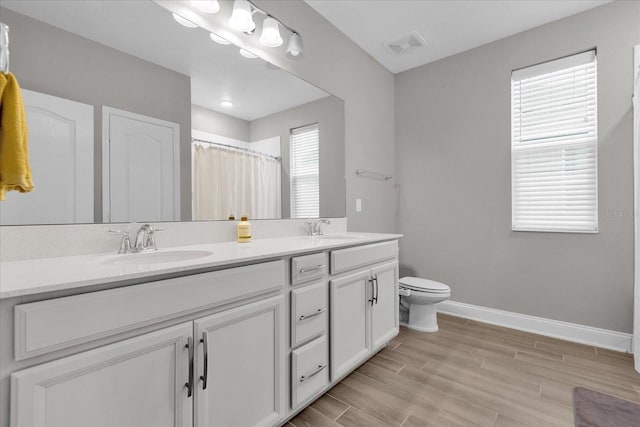 bathroom with vanity, curtained shower, hardwood / wood-style flooring, and toilet