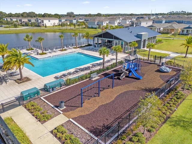 view of pool with a water view, a patio, a playground, and a yard