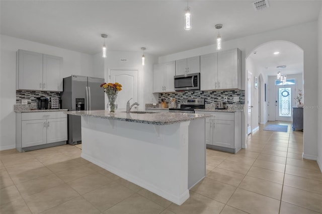 kitchen with tasteful backsplash, sink, an island with sink, and stainless steel appliances