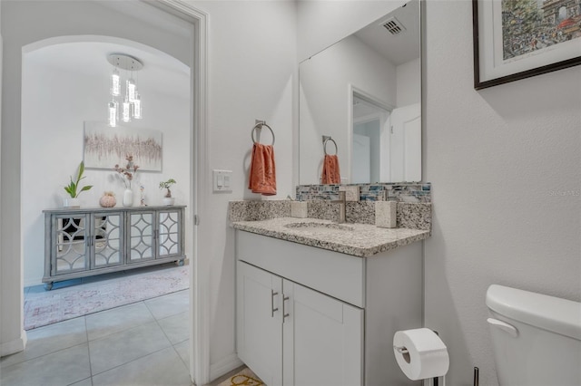 bathroom with tile patterned flooring, vanity, and toilet