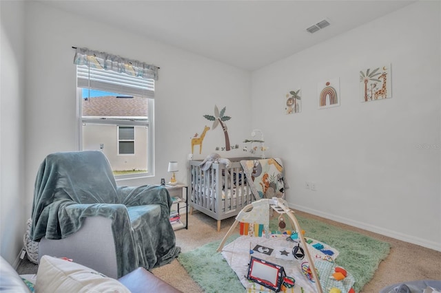 carpeted bedroom featuring a nursery area