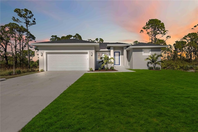 view of front facade featuring a garage and a yard