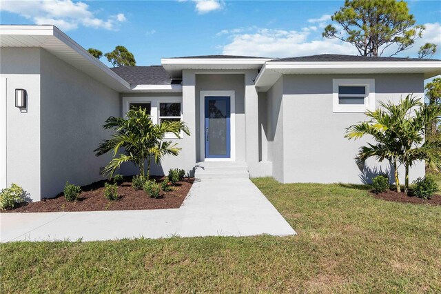 entrance to property with a lawn