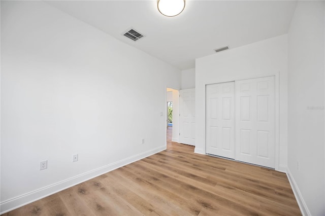 unfurnished bedroom featuring hardwood / wood-style flooring and a closet