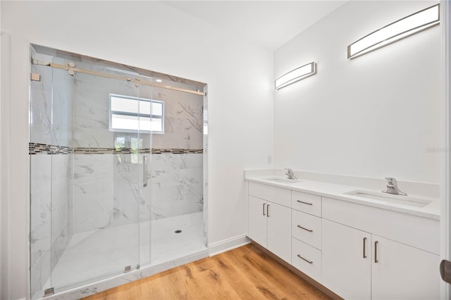 bathroom with hardwood / wood-style floors, vanity, and a shower with door