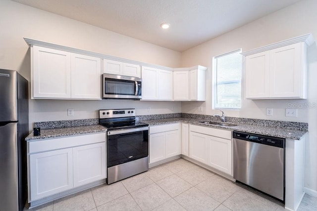 kitchen with stainless steel appliances, sink, and white cabinets