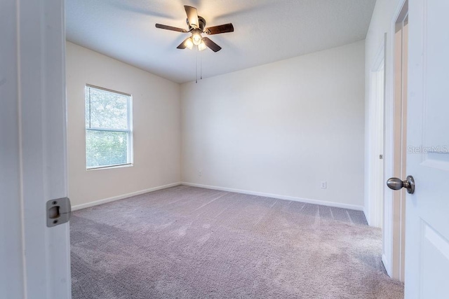 spare room featuring light carpet and ceiling fan