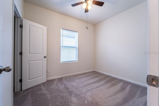 carpeted spare room featuring ceiling fan