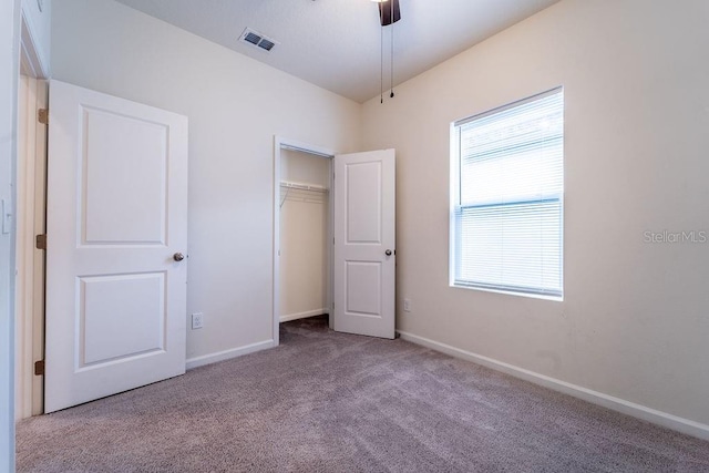 unfurnished bedroom featuring light carpet, a closet, and ceiling fan