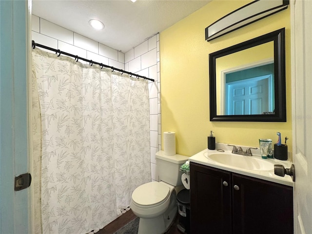 bathroom with vanity, toilet, a textured ceiling, and curtained shower