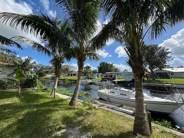 dock area featuring a water view and a lawn