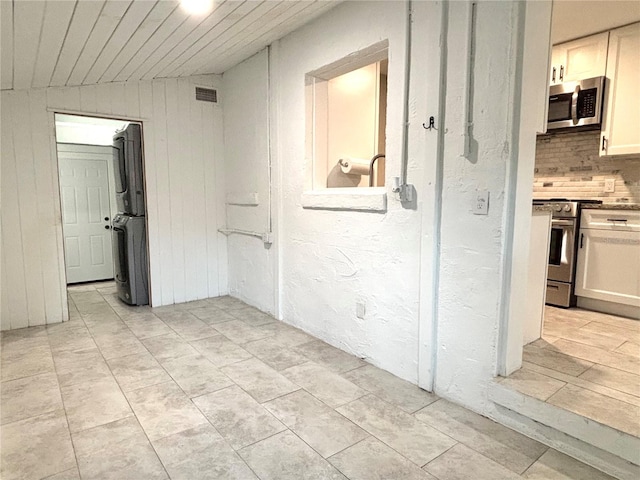 corridor featuring wood walls, vaulted ceiling, light tile patterned flooring, and wooden ceiling