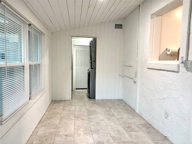 hallway featuring light tile patterned floors, wooden ceiling, and vaulted ceiling