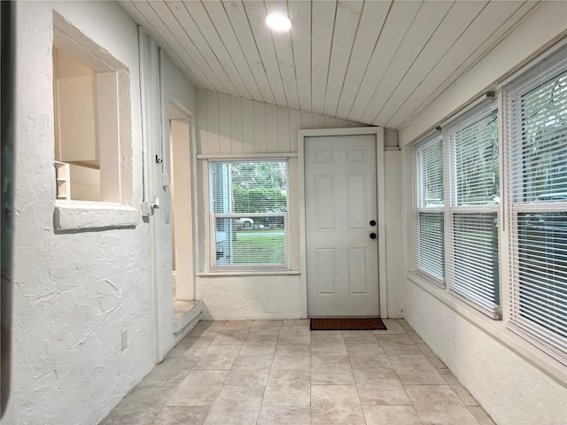 doorway with wood ceiling, vaulted ceiling, and light tile patterned floors