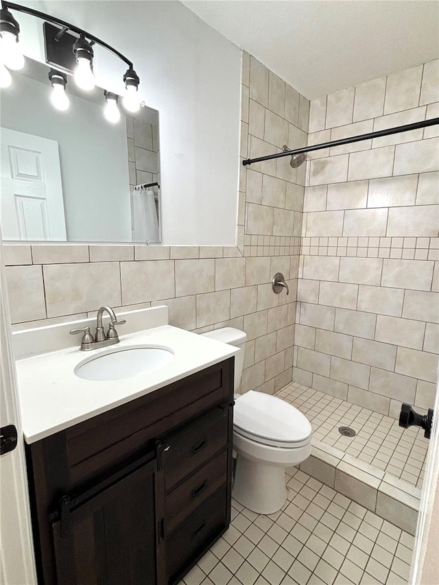 bathroom featuring tile walls, vanity, toilet, and walk in shower