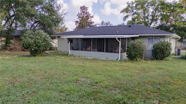 rear view of property featuring a sunroom, a lawn, and cooling unit