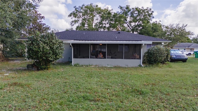 rear view of house with a lawn and a sunroom