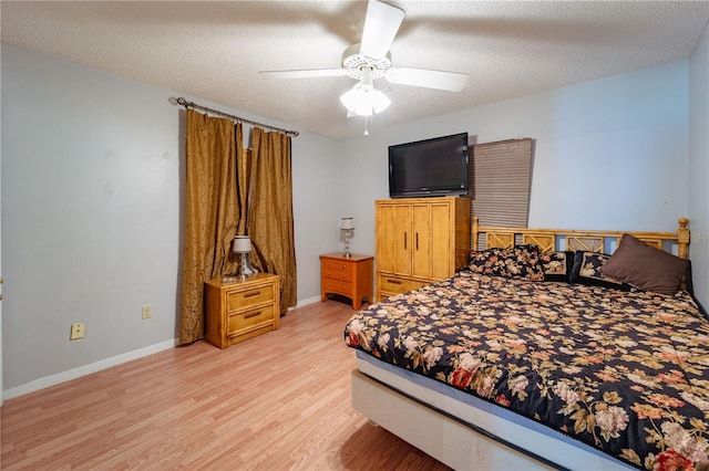 bedroom with light hardwood / wood-style floors, a textured ceiling, and ceiling fan