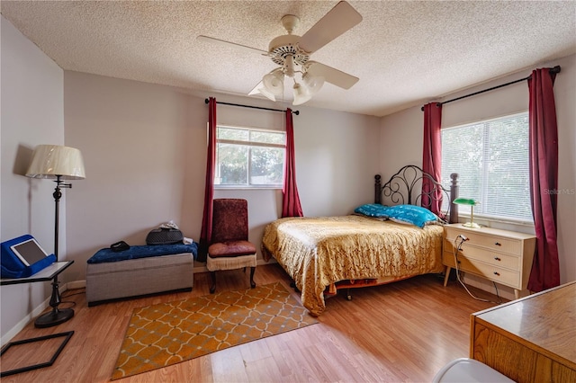 bedroom featuring ceiling fan, a textured ceiling, and hardwood / wood-style floors