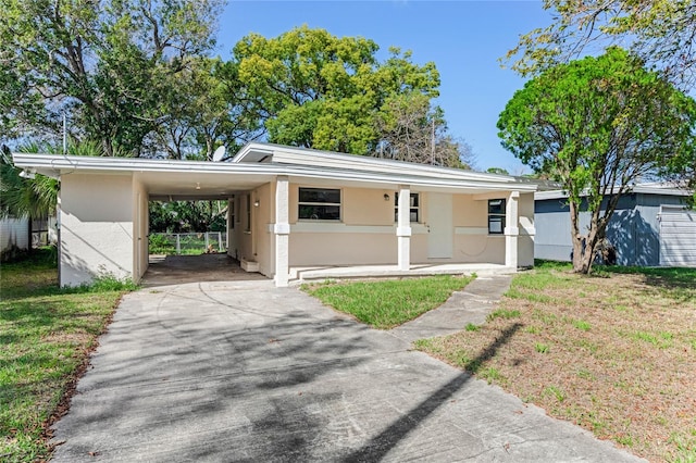 view of front of home with a front yard and a carport