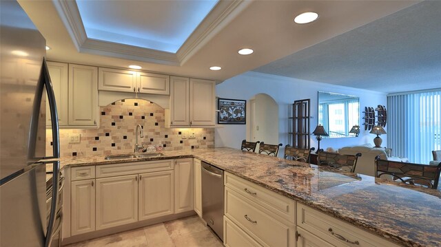 2987 S Atlantic Ave Unit D060, Daytona Beach, FL 32118 - kitchen with arched walkways, tasteful backsplash, a sink, stone countertops, and stainless steel appliances